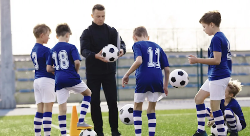 soccer-coach-showing-boys-how-to-juggle-soccer-ball